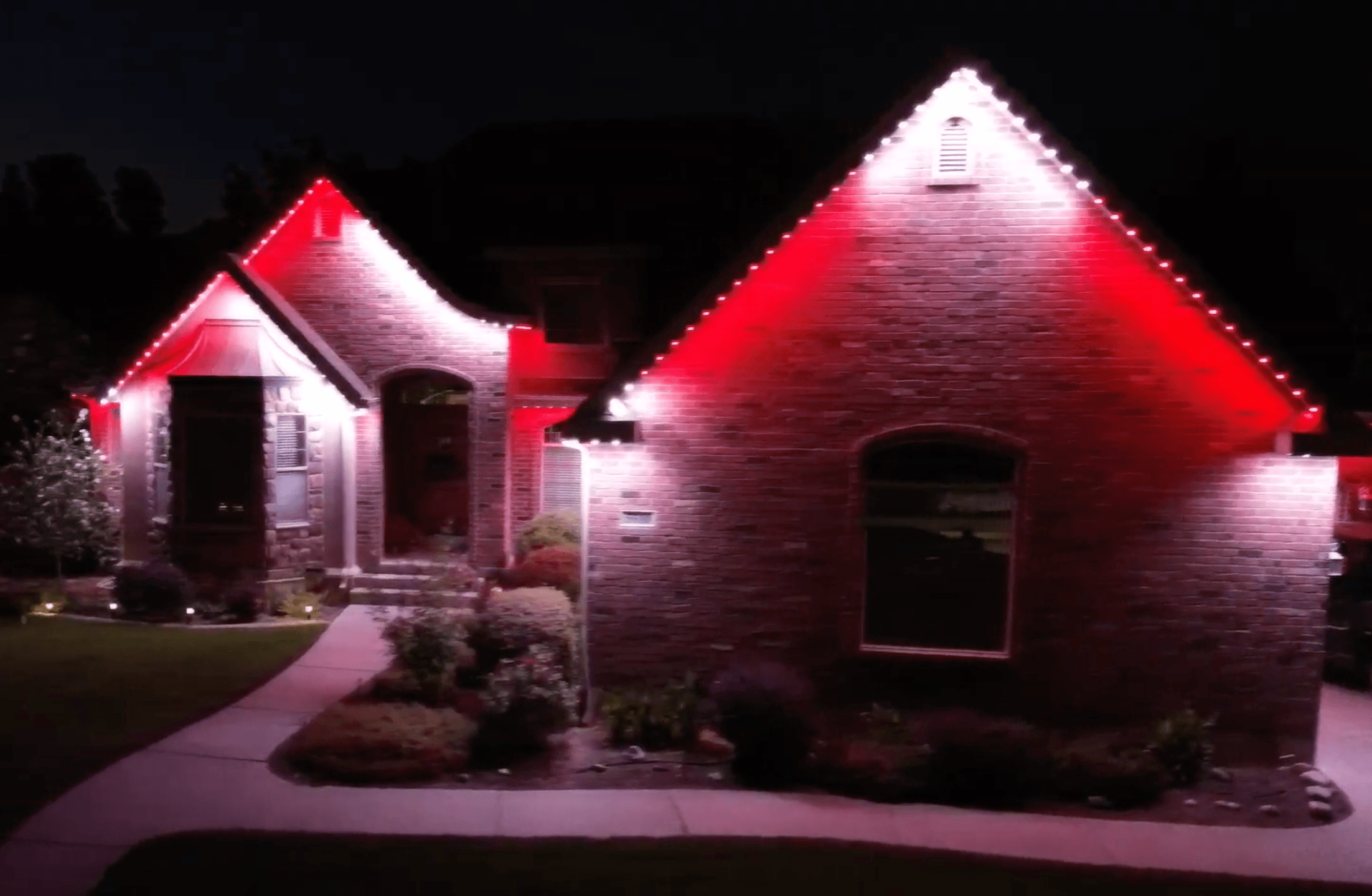 Permanent Christmas lights in candy cane red and white pattern on a home (TruLight network install)